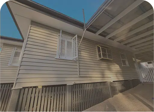 White weatherboard house exterior with carport