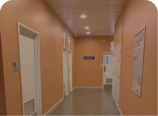 Orange corridor with restroom doors and signage